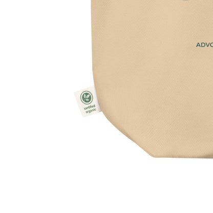 Close-up of a beige woven fabric product corner with a small white Certiﬁed Organic tag attached, shown on a plain white background.