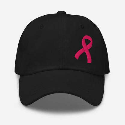 A black baseball cap featuring a vibrant pink embroidered breast cancer awareness ribbon on the front right side, set against a clean light gray background.