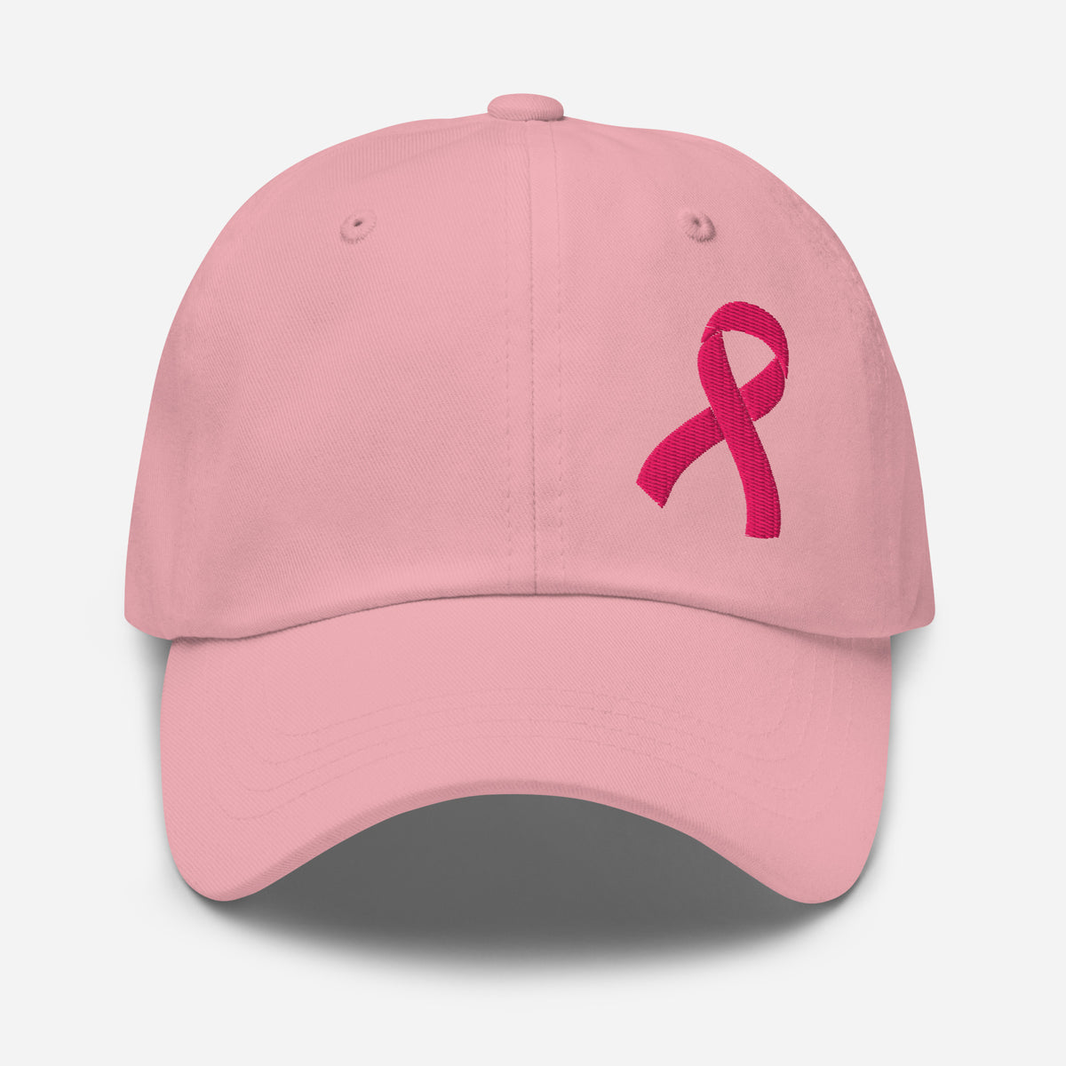 A light pink baseball cap featuring a darker pink breast cancer awareness embroidered ribbon on the front, set against a clean light gray background.