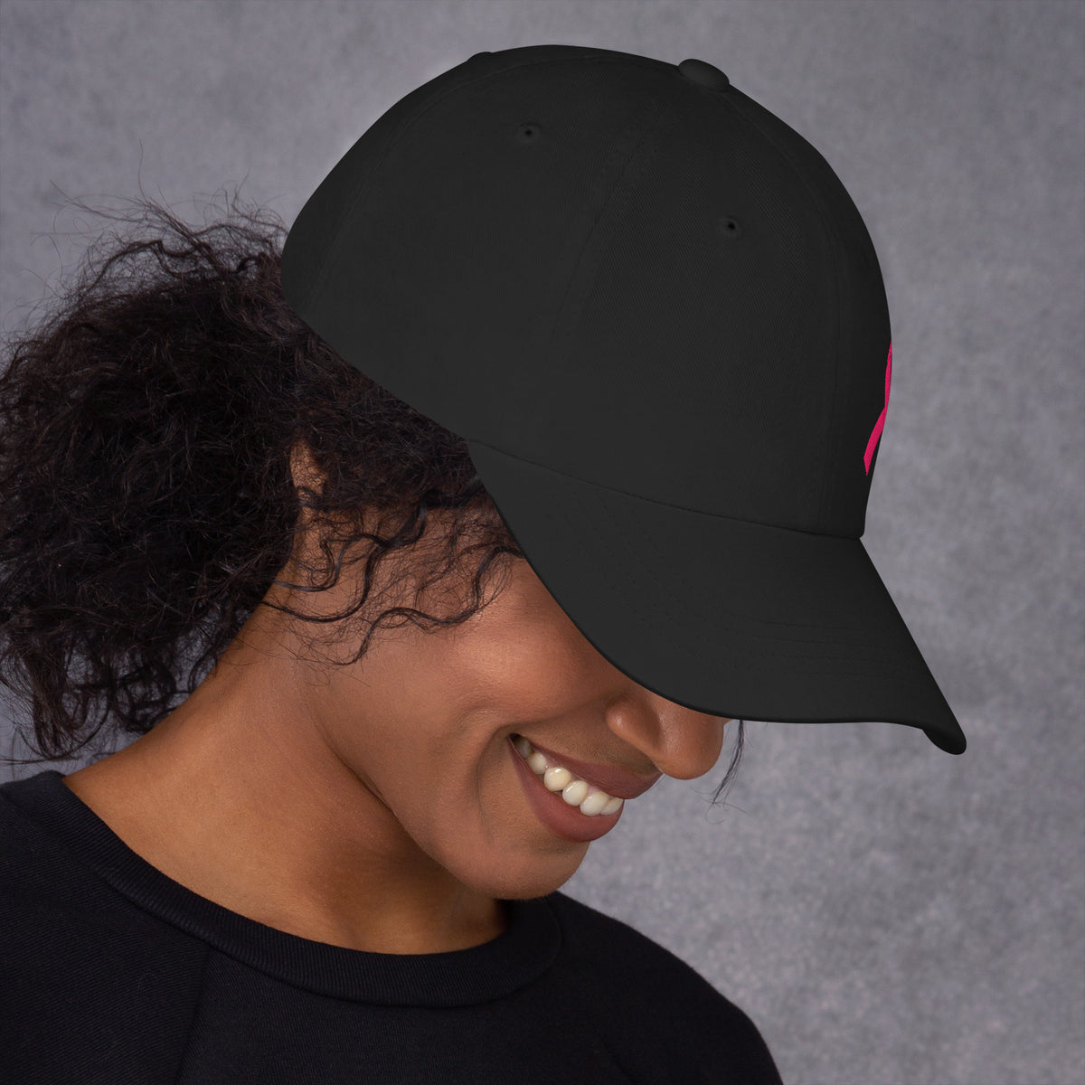 Person wearing a black cap against a gray background