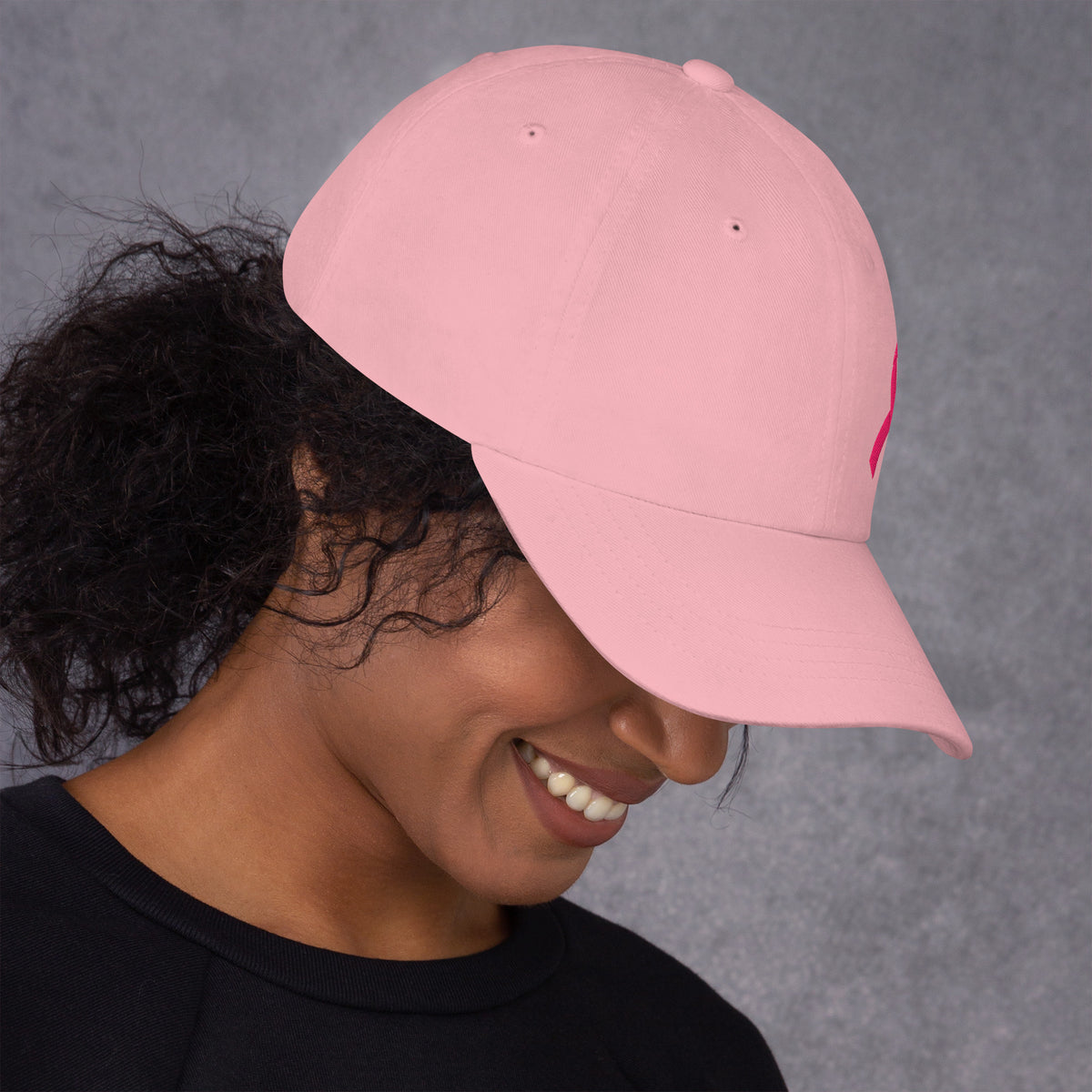 Person wearing a pink cap against a gray background