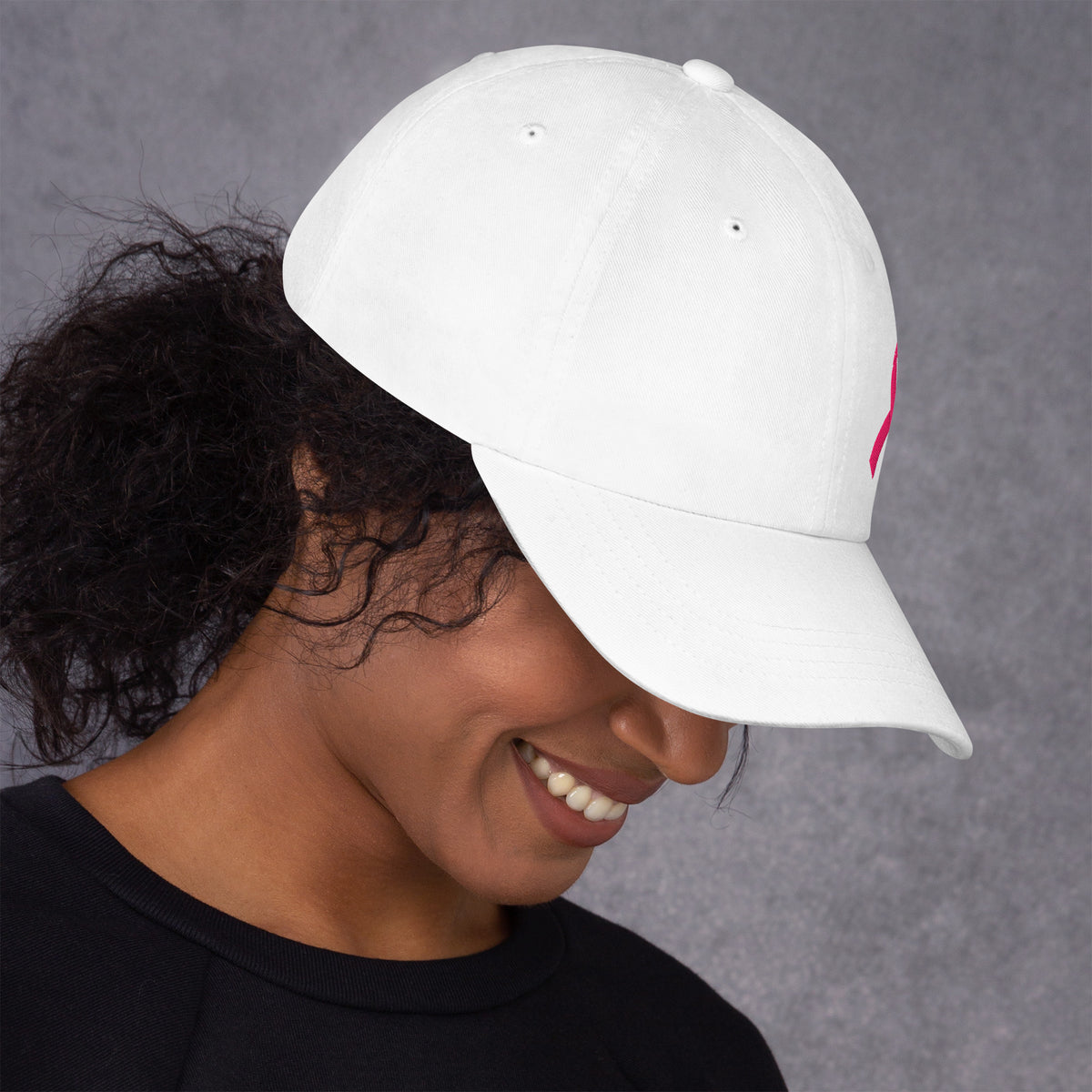 Person wearing a white cap with a logo on a gray background