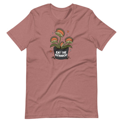 A dusty rose short-sleeve t-shirt with a graphic of three carnivorous Venus flytraps in a pot that reads 'EAT THE PATRIARCHY' in white text, shown on a plain white background.